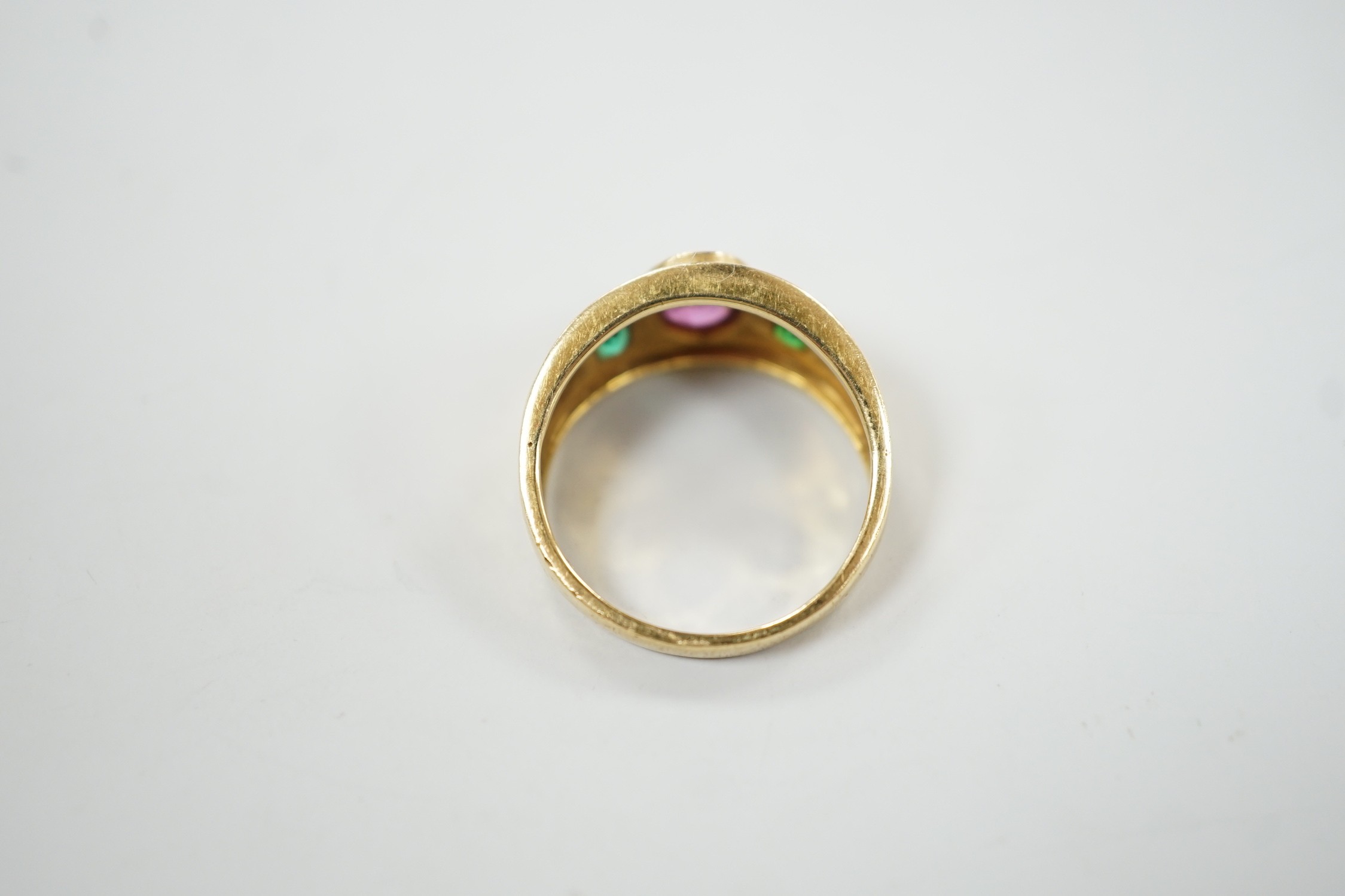 A modern 14k, collet set ruby and green paste? three stone ring, size L, gross weight 4 grams.